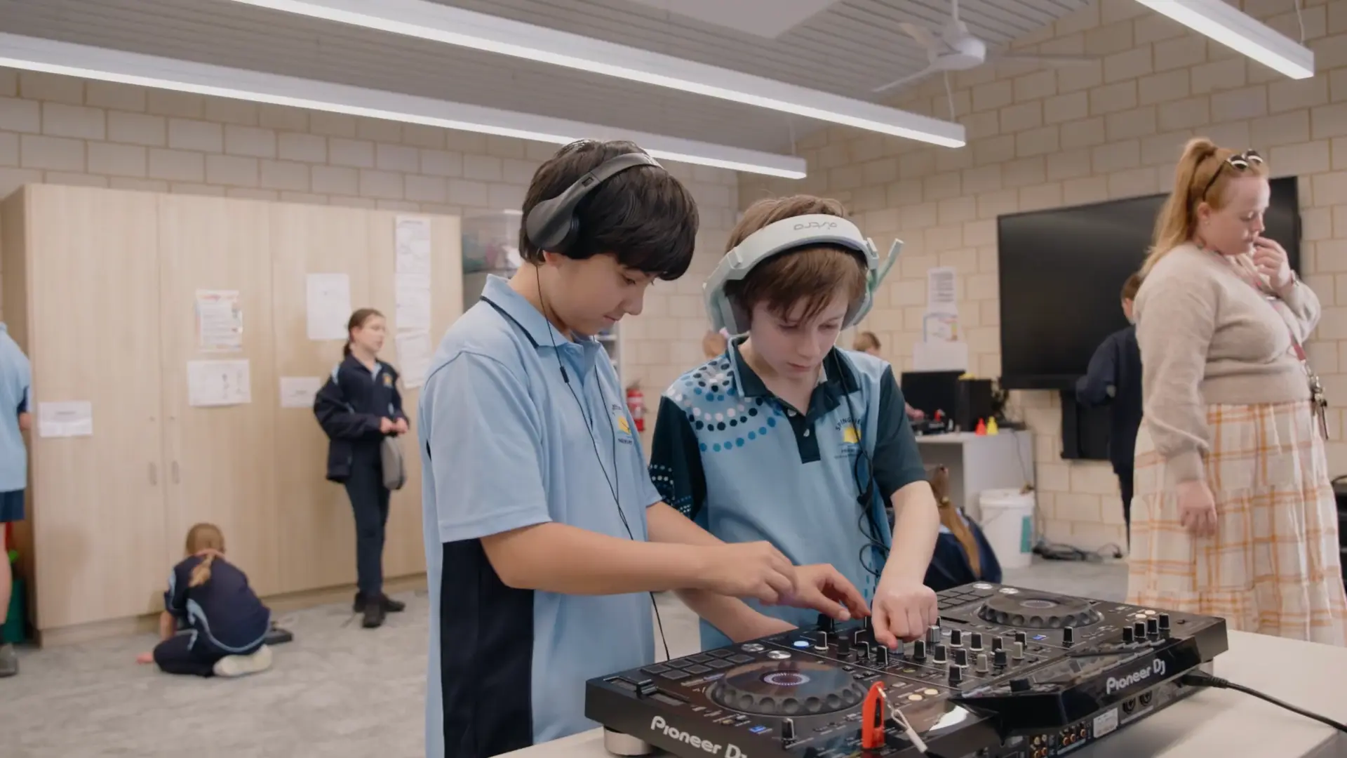 Two students learning together on Pioneer DJ decks