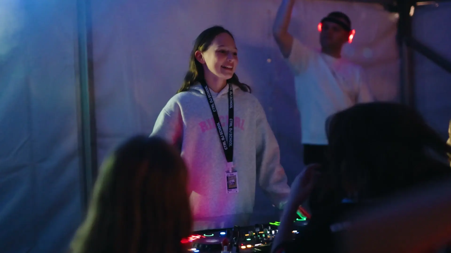 A young DJ smiling while performing for a crowd